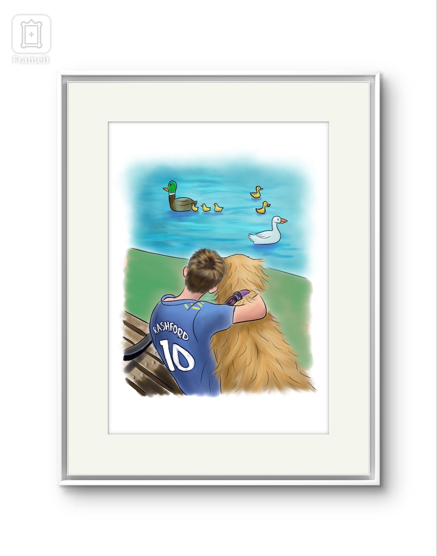 Framed picture of an illustration of a boy wearing a blue football shirt with Rashford and the number 10 on it, with him arm round a golden retriever. They’re sitting on a bench looking out at a duck pond. There are illustrated ducks in the pond.