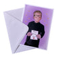 Illustration card with envelope of a boy smiling, wearing glasses and a black hoodie holding a sign saying happy birthday Alex. The background is purple with yellow stars. 